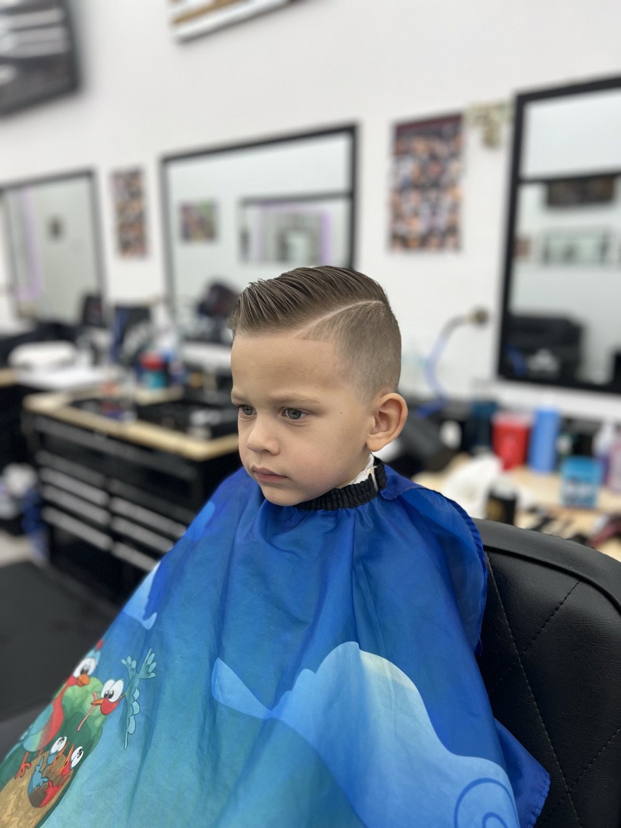 Kids' side-part haircut with a clean fade at Luke's Barber Shop