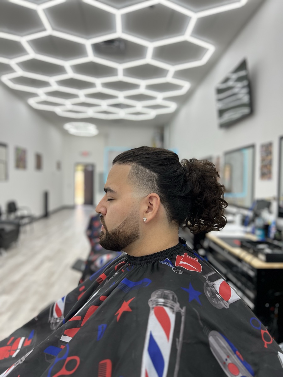 Clean side fade and shaped beard around an existing long hairstyle at Luke's Barber Shop
