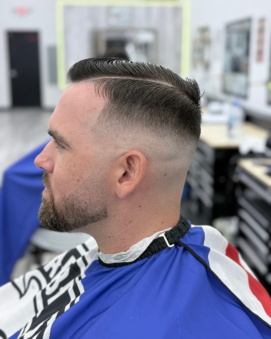 Slicked side-part haircut with a clean skin fade at Luke's Barber Shop