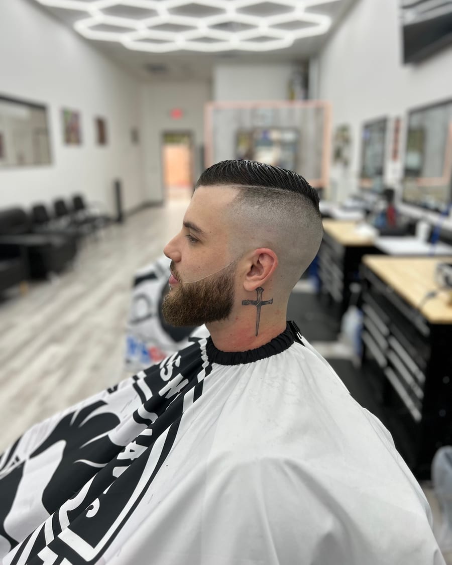 Fresh slicked side-part haircut with a skin fade and shaped beard at Luke's Barber Shop