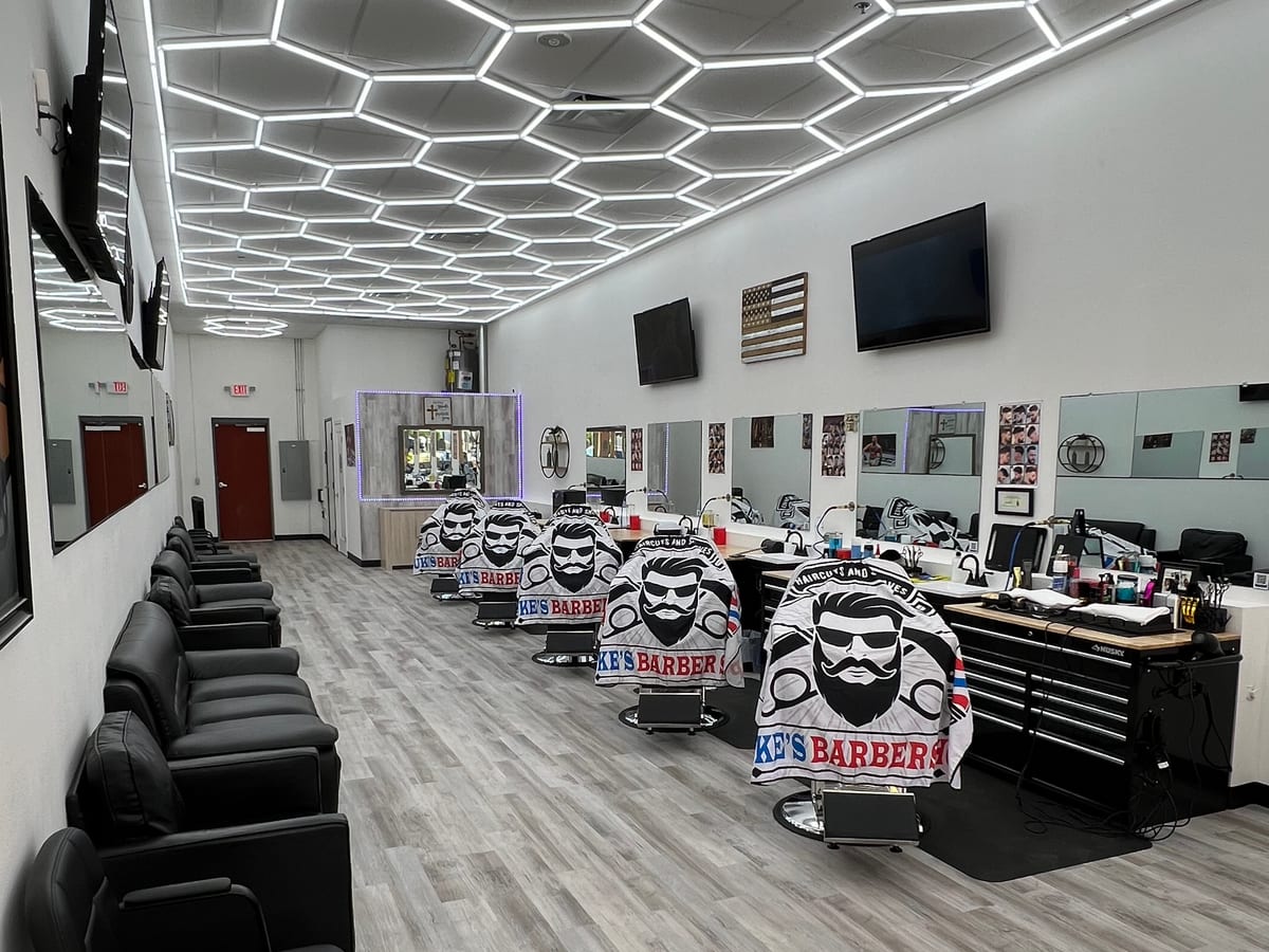 Interior of Luke's Barber Shop with barber chairs, mirrors and geometric ceiling lights